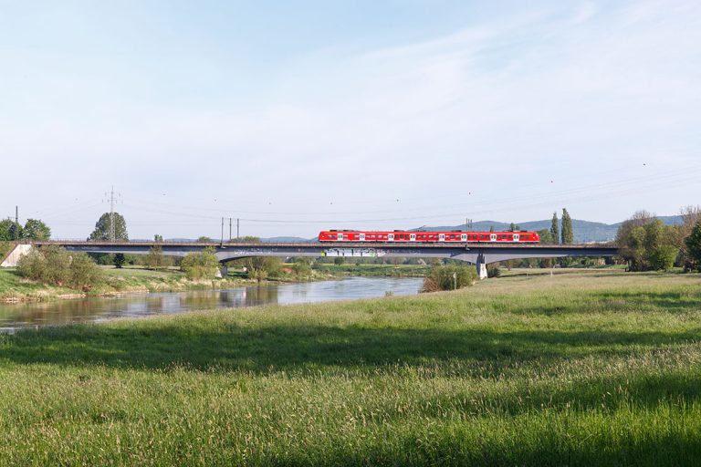 Ulla Anne Giesen Fotografie – Dokumentarfotografie Raum Nordrhein-Westfalen – Bereich Arbeit - Abbildung: OSTWESTFALEN LIPPE Porta Westfalica, Weser, Verkehr, Bahnbrücke, Regionalbahn, Wiese, Aue